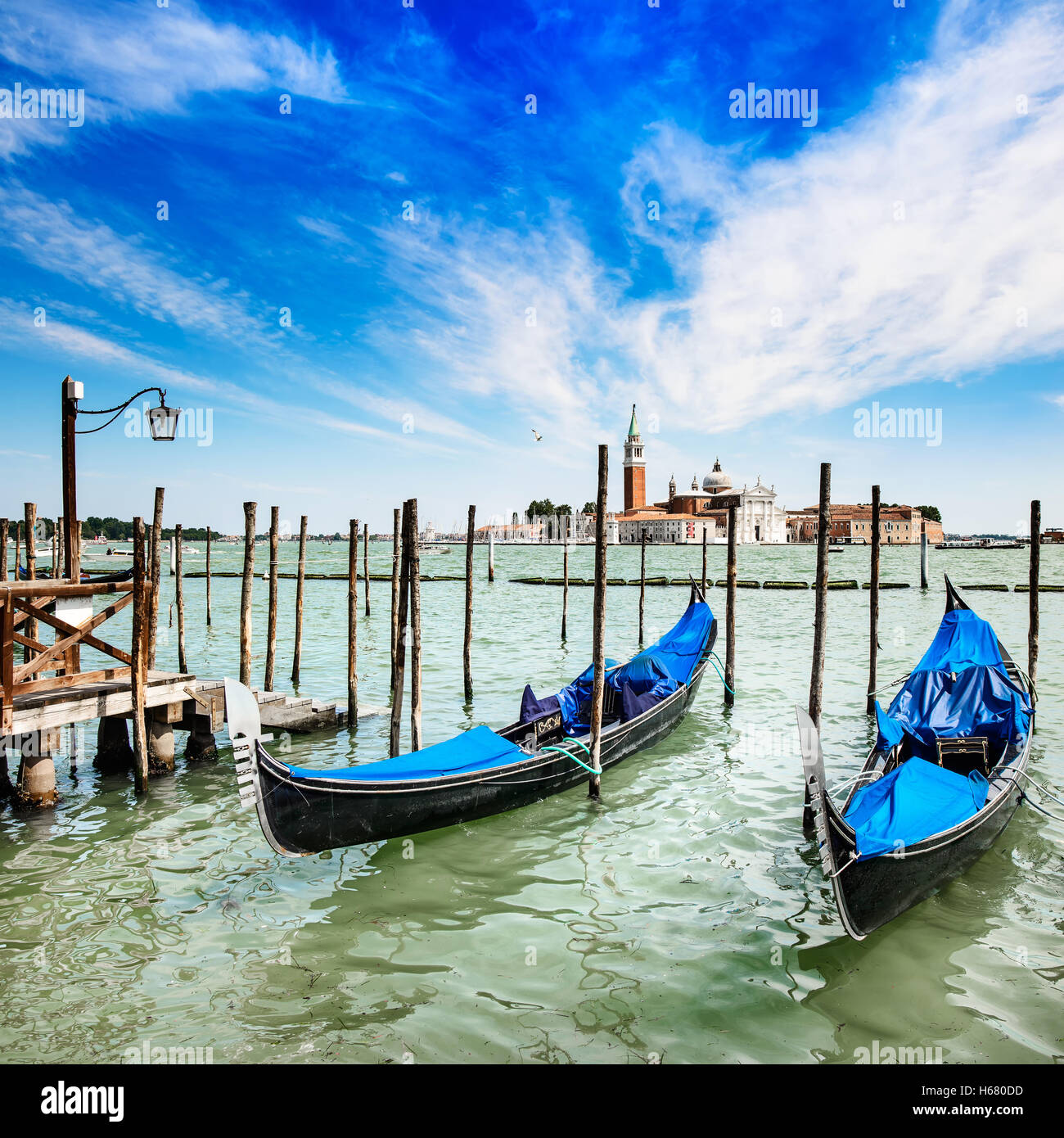 Venedig, Gondeln oder Gondeln auf einem blauen Himmel und San Giorgio Maggiore Kirche Wahrzeichen auf Hintergrund. Italien, Europa. Stockfoto
