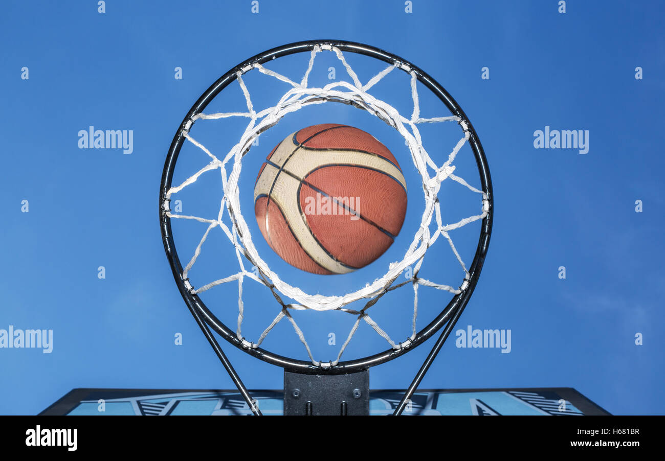 Basketball fallen durch das Netz. Blauen Himmel im Hintergrund. Stockfoto