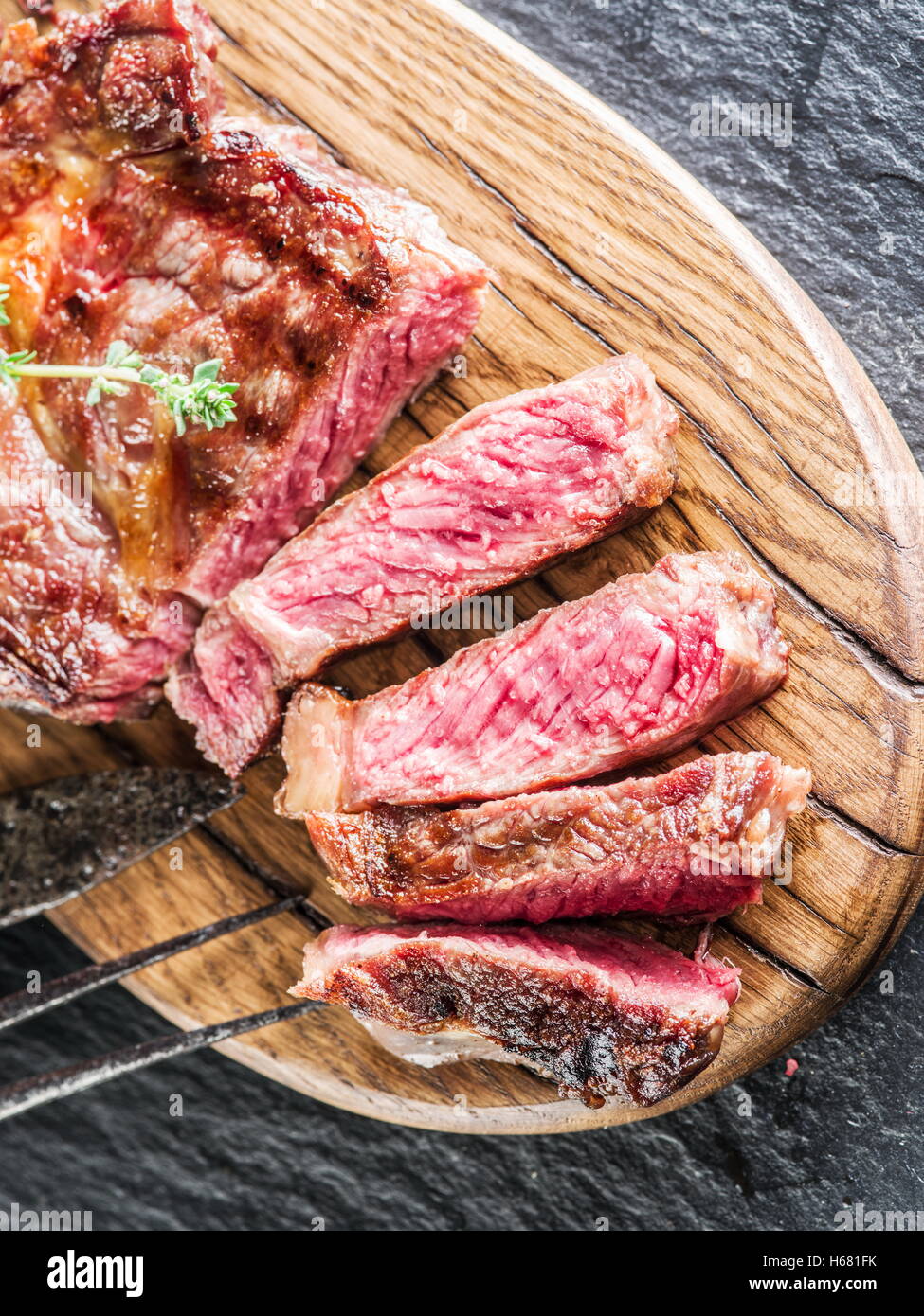 Mittlere Ribeye-Steak auf dem Tablett aus Holz. Stockfoto
