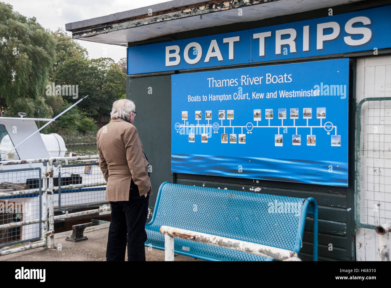 Ein reifer Mann Lesen der Infotafel für Ausflüge mit dem Boot entlang der Themse in Richmond in Surrey, England Stockfoto