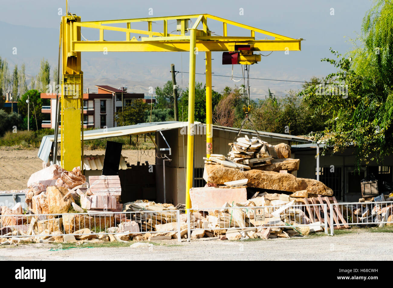 Gelbe Kran zum Heben von Platten und Blöcke bei einem Steinmetz Yard verwendet. Stockfoto