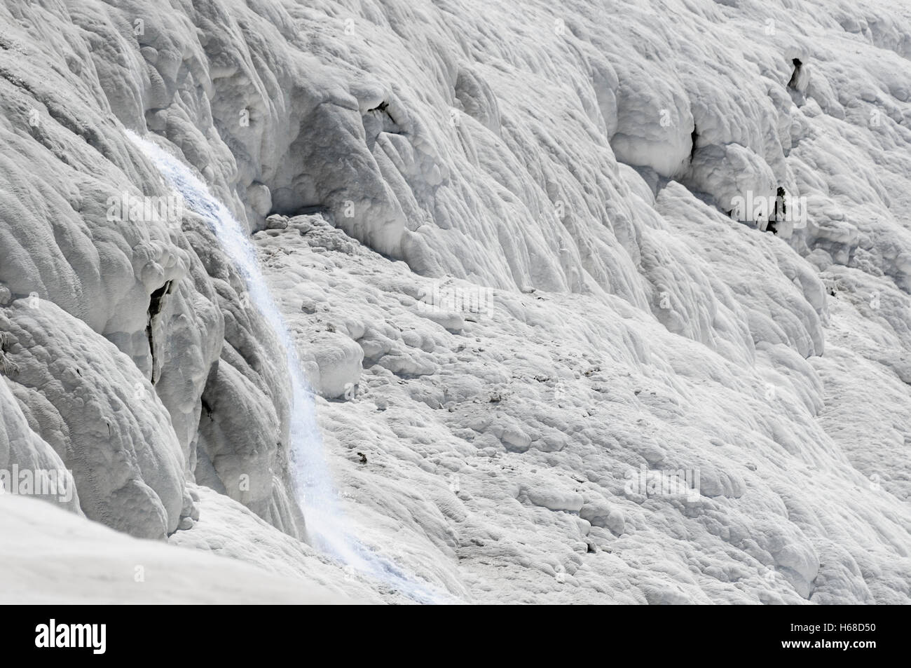 Wasserfall fließt über die weißen Kalkablagerungen an den Thermalquellen in Pamakkule, Türkei Stockfoto