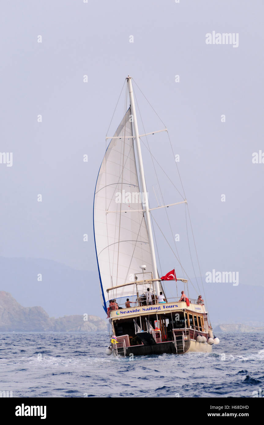 Eine Segelschiff hat seine Fock entfaltet, als es eine Bucht in der Türkei überquert. Stockfoto