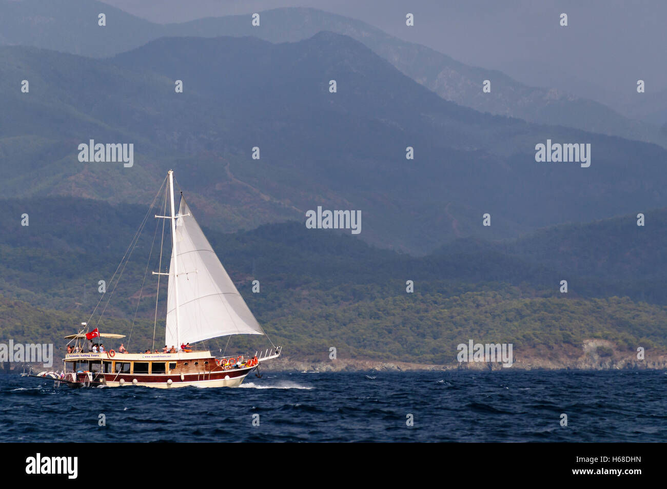 Eine Segelschiff hat seine Fock entfaltet, als es eine Bucht in der Türkei überquert. Stockfoto