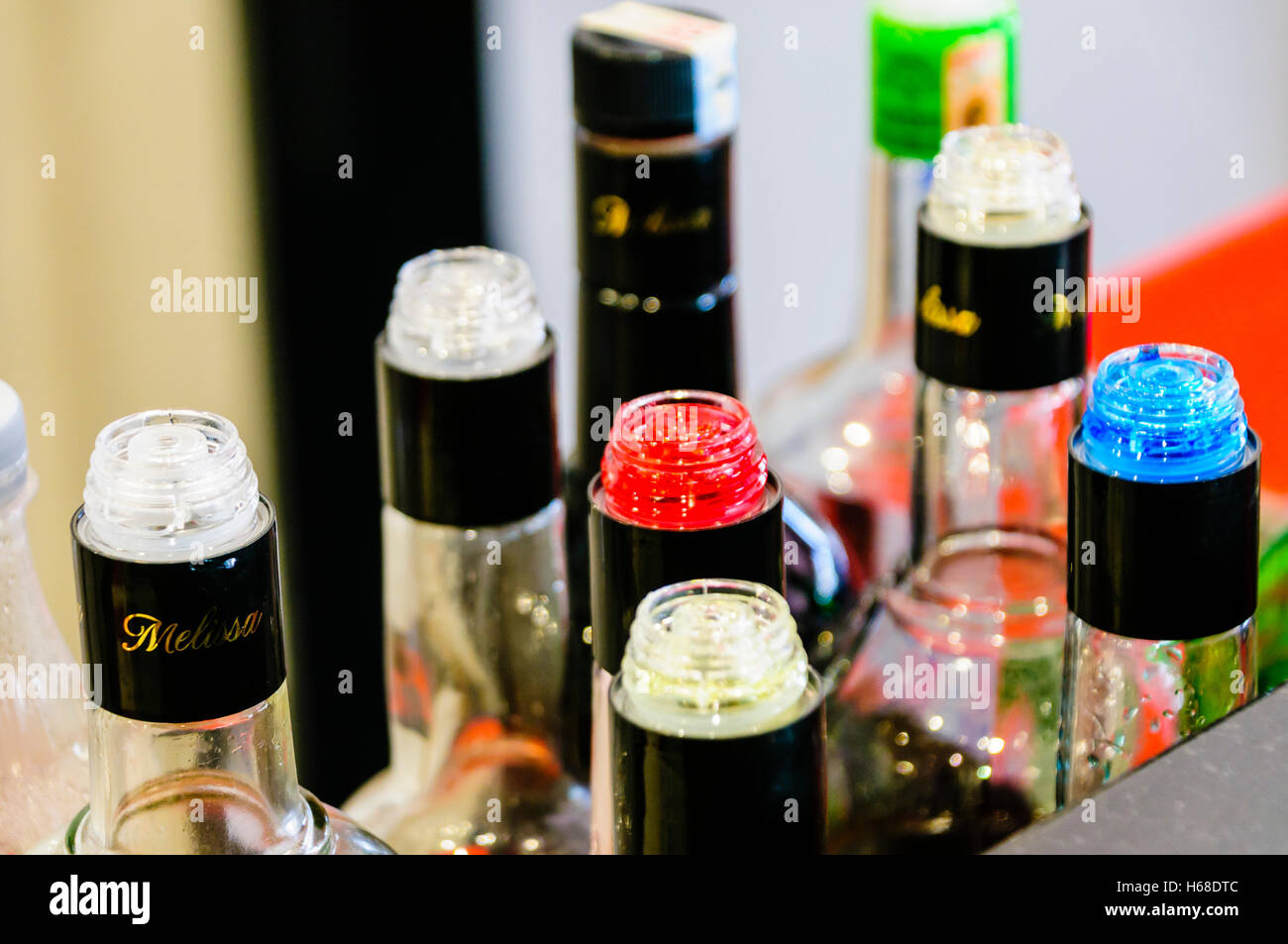 Mehrfarbige Flaschen auf dem Tresen einer Bar mit plastisches fließen  Begrenzer/Geschwindigkeit Ausgießer zu gewährleisten genaue Gießen durch  zählen der Anzahl von Sekunden Stockfotografie - Alamy