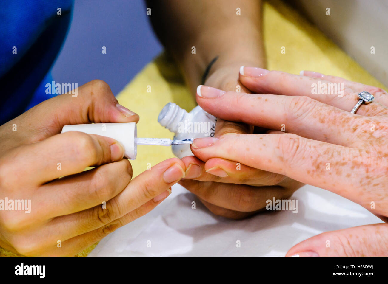 Eine Frau hat eine French Manicure Nagel Lack Behandlung in einem Schönheitssalon. Stockfoto