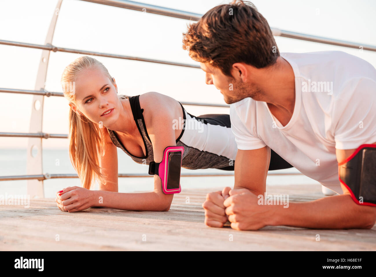 Nahaufnahme einer jungen Fitness Frau und Mann gemeinsam Plank Übung im Freien an der pier Stockfoto