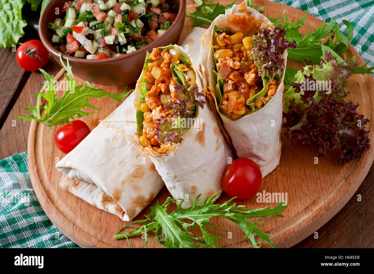 Burritos wraps mit Hackfleisch und Gemüse auf einem hölzernen Hintergrund. Stockfoto