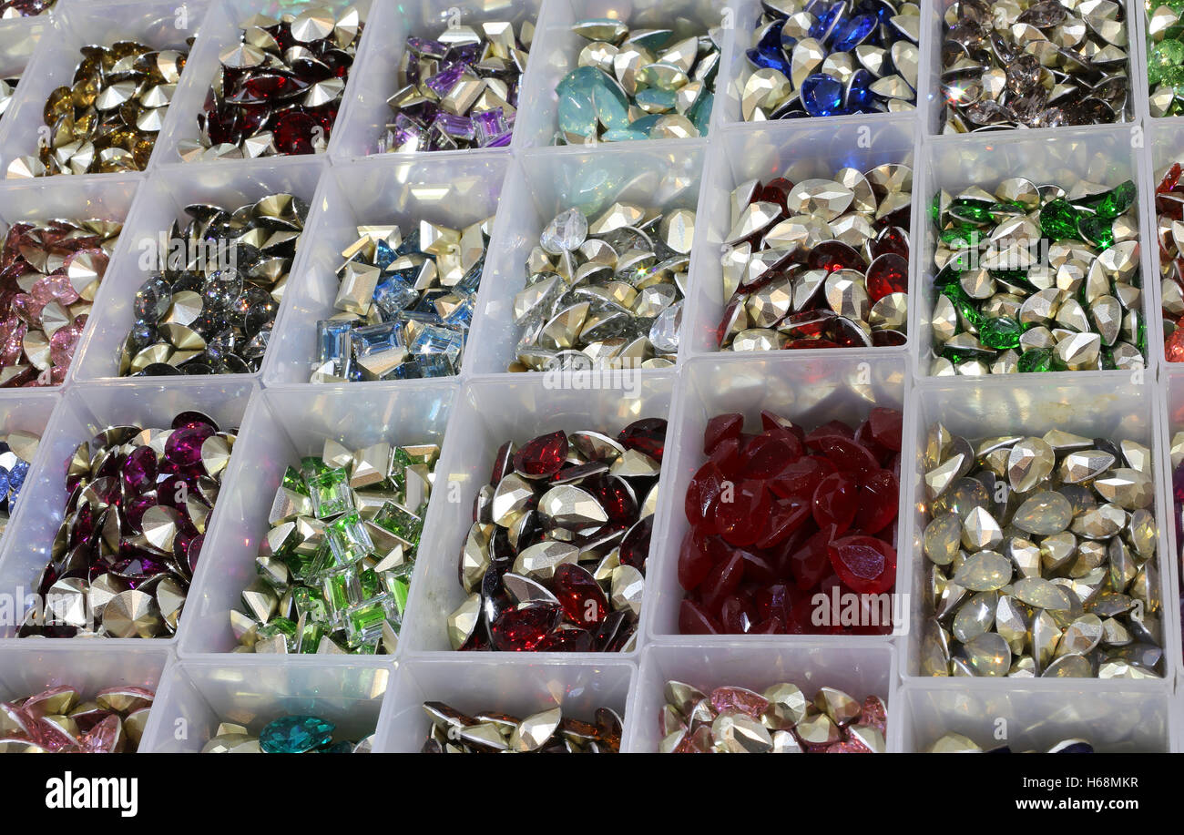 Kunststoffboxen mit Diademe und Steinen für Dekoration und Halsketten in Kurzwaren Stockfoto