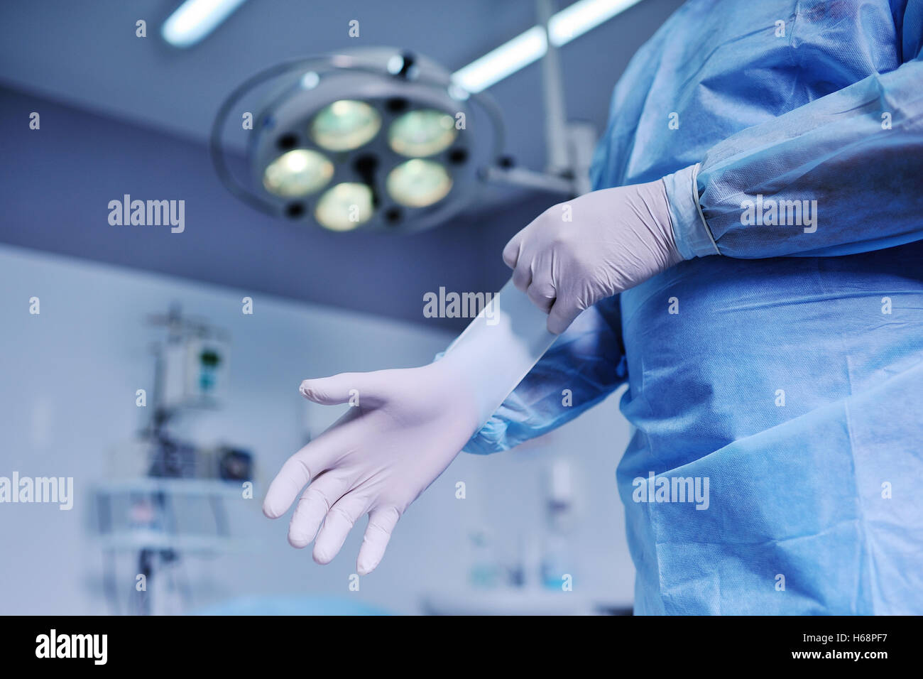 der Chirurg setzt auf Latexhandschuhe Hintergrund der Betriebs- Stockfoto