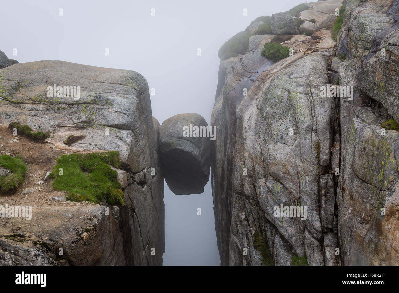 Kjerag-Stein, an der Steilküste zwischen zwei hohen Felsen hängen. Stockfoto