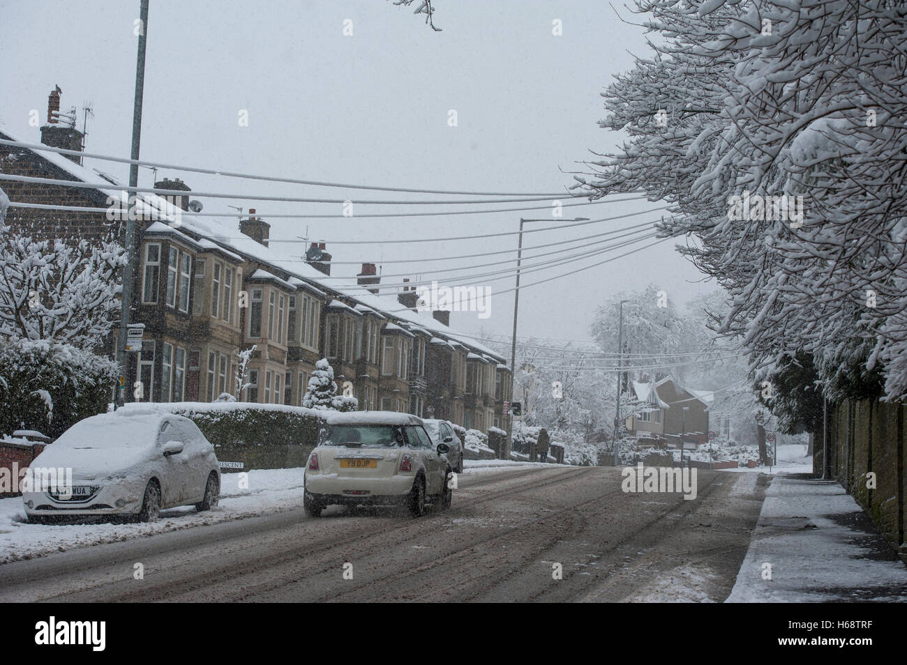 Nördlichen Winter Straße bedeckt mit Schnee, Straße und Autos mit Schneedecke, Freileitungen abgedeckt, während immer noch Schnee fällt. Stockfoto