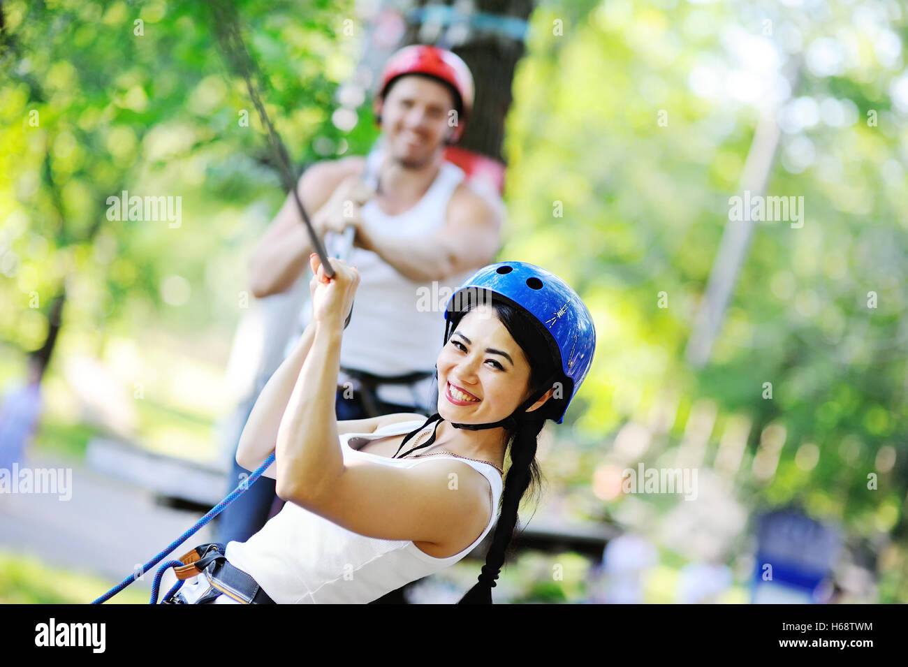 Paare, die Spaß im Park an einem Seil Weg Stockfoto