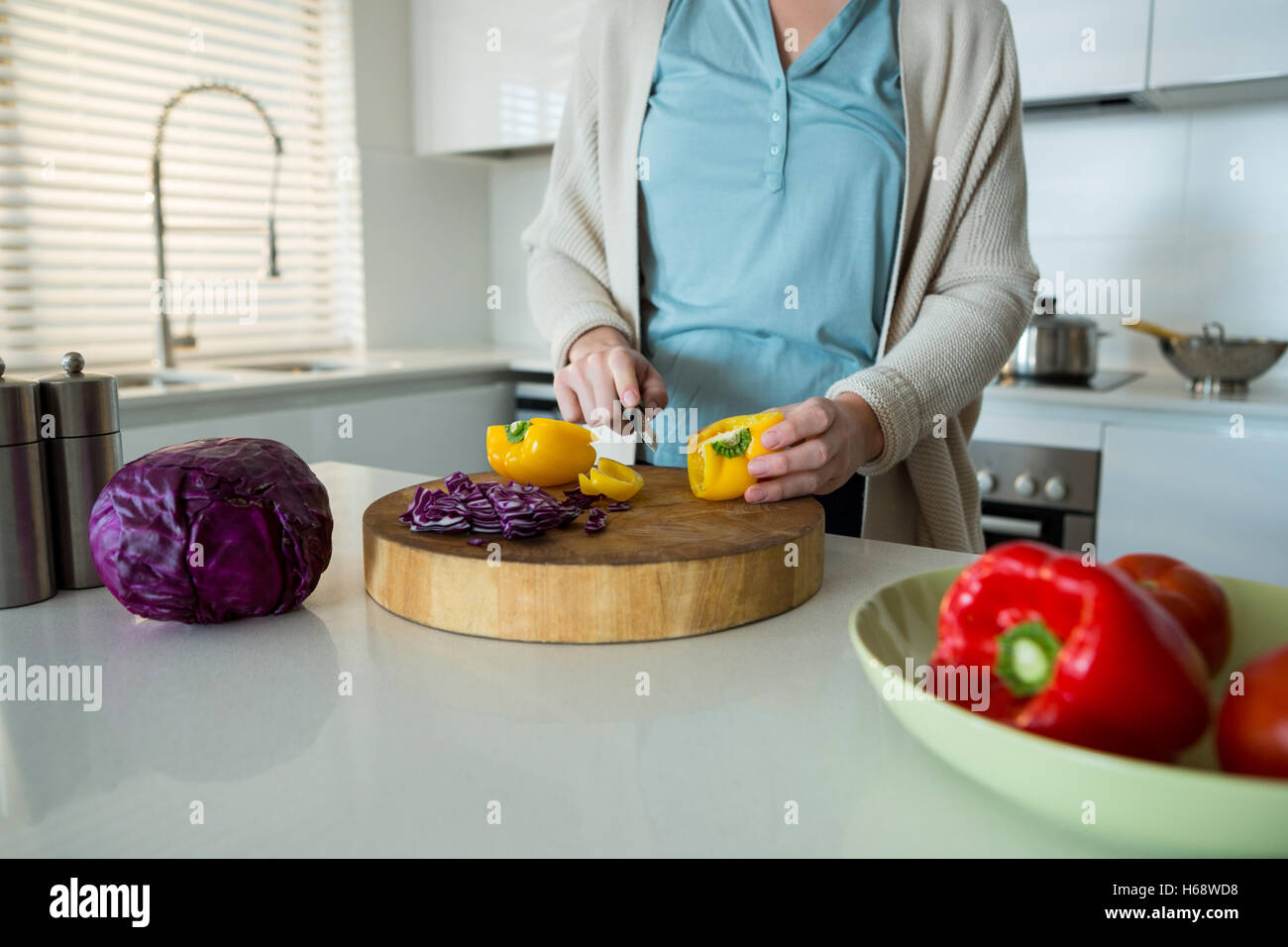 Mittleren Bereich der Frauenbeschneidung gelbe Paprika in Küche Stockfoto