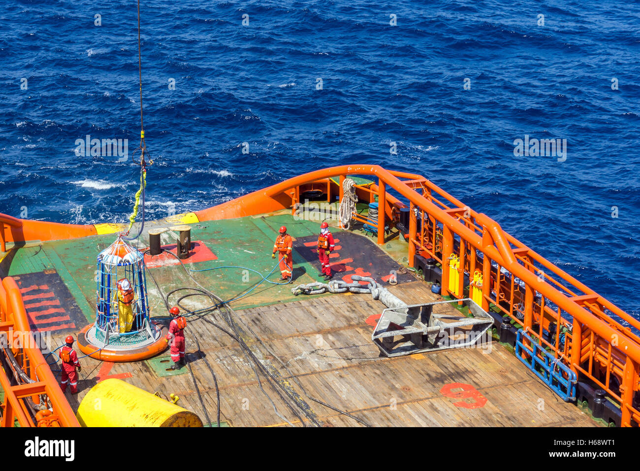 In der Lage körperreich Seeleute, die Unterstützung der Offshore-Arbeiter, die Übertragung von Anchor handling Tug Barge mit persönlichen Transfer Korb arbeiten Stockfoto