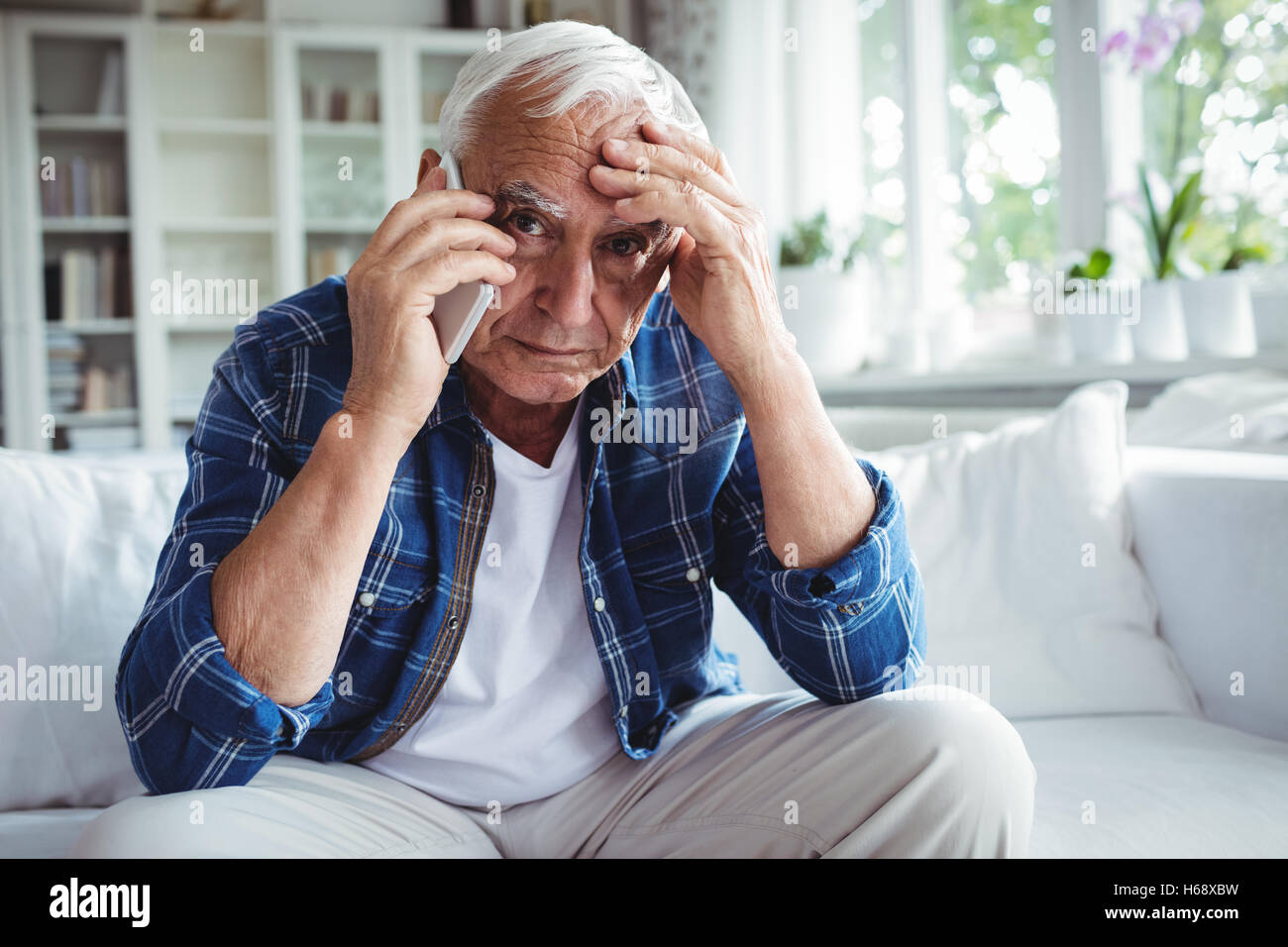Gespannten senior woman telefonieren mit Handy Stockfoto
