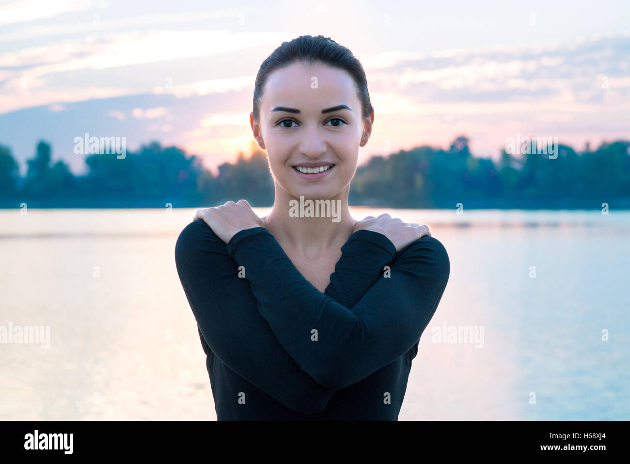 Junge hübsche Frau Porträt im frühen Morgen in die farbenfrohen Sonnenaufgang Hintergrund Stockfoto