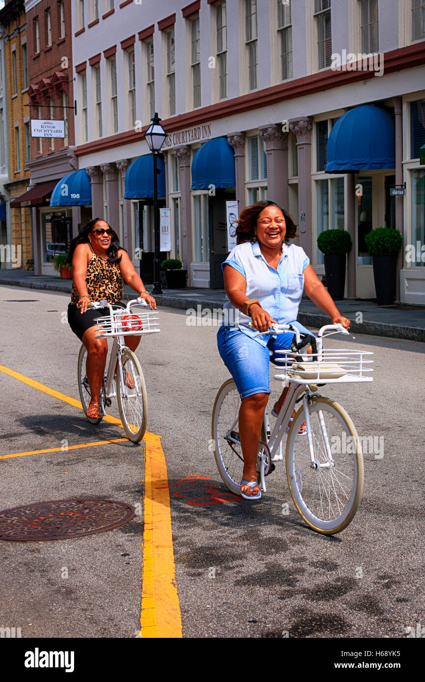 Frauen von Farbe auf eine weiße Vermietung Fahrrädern entlang der Straße in Charleston, SC Stockfoto