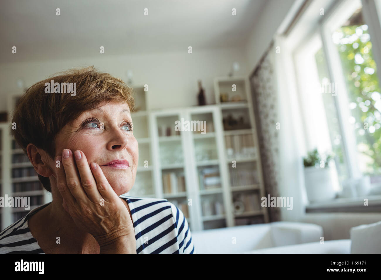 Nachdenklich senior Frau sitzt auf dem Sofa im Wohnzimmer Stockfoto