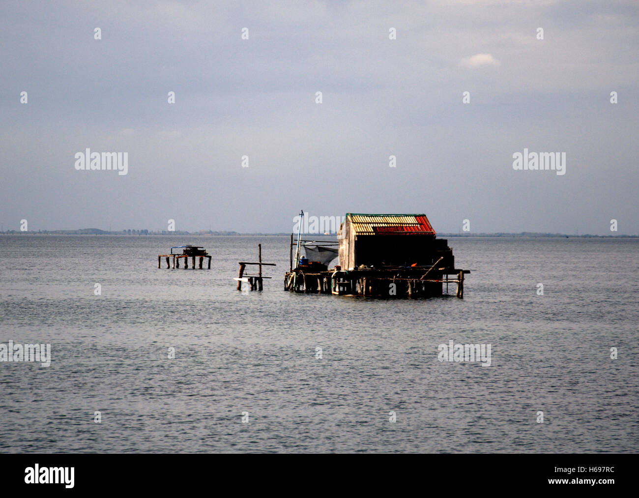 Eine Fischerhütte scheint isoliert im Wasser der Lagune südlich von Venedig Stockfoto