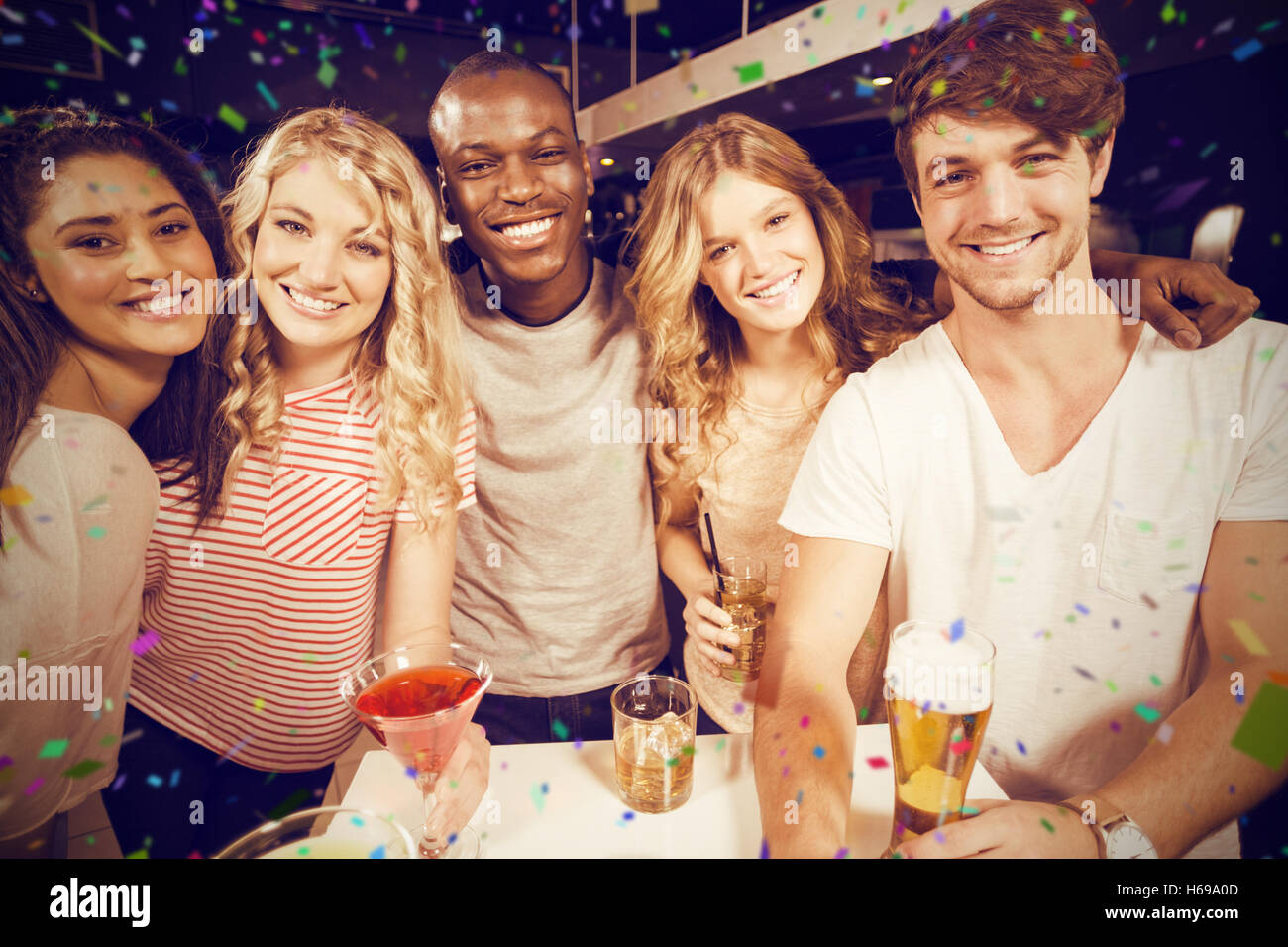 Zusammengesetztes Bild Porträt der happy Friends mit Bier und Cocktails auf Tisch Stockfoto
