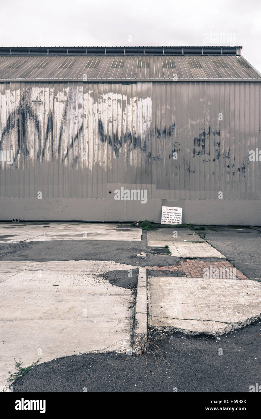 Alte graue Lager an einem bewölkten Tag mit gereinigten Graffiti und nicht übereinstimmende und baufälligen viel Stockfoto