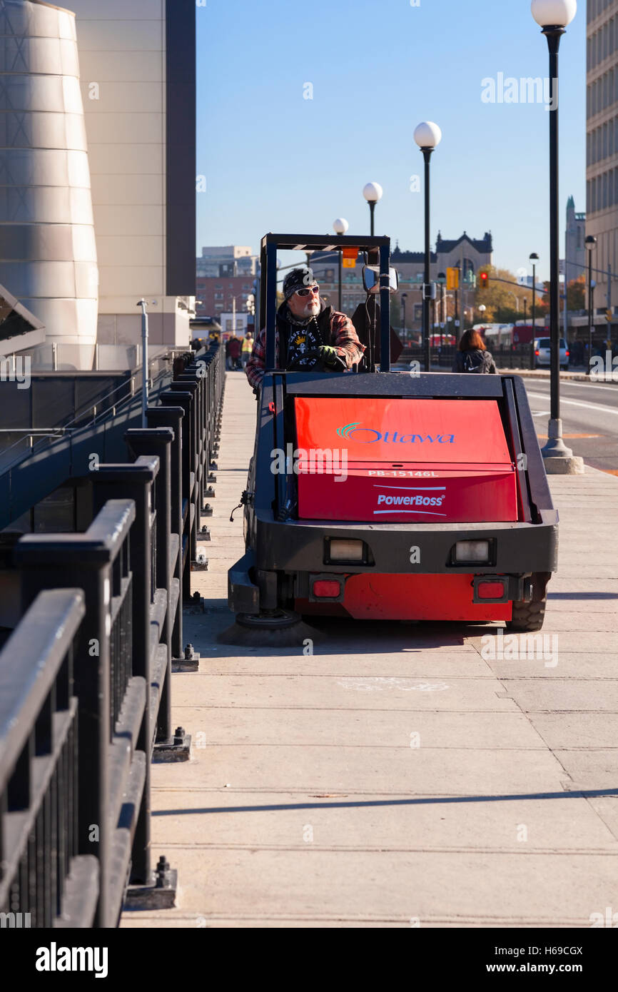 Ein Stadt-Arbeiter Reiten eine Bürgersteig Kehrmaschine in der Innenstadt von Ottawa, Ontario, Kanada. Stockfoto