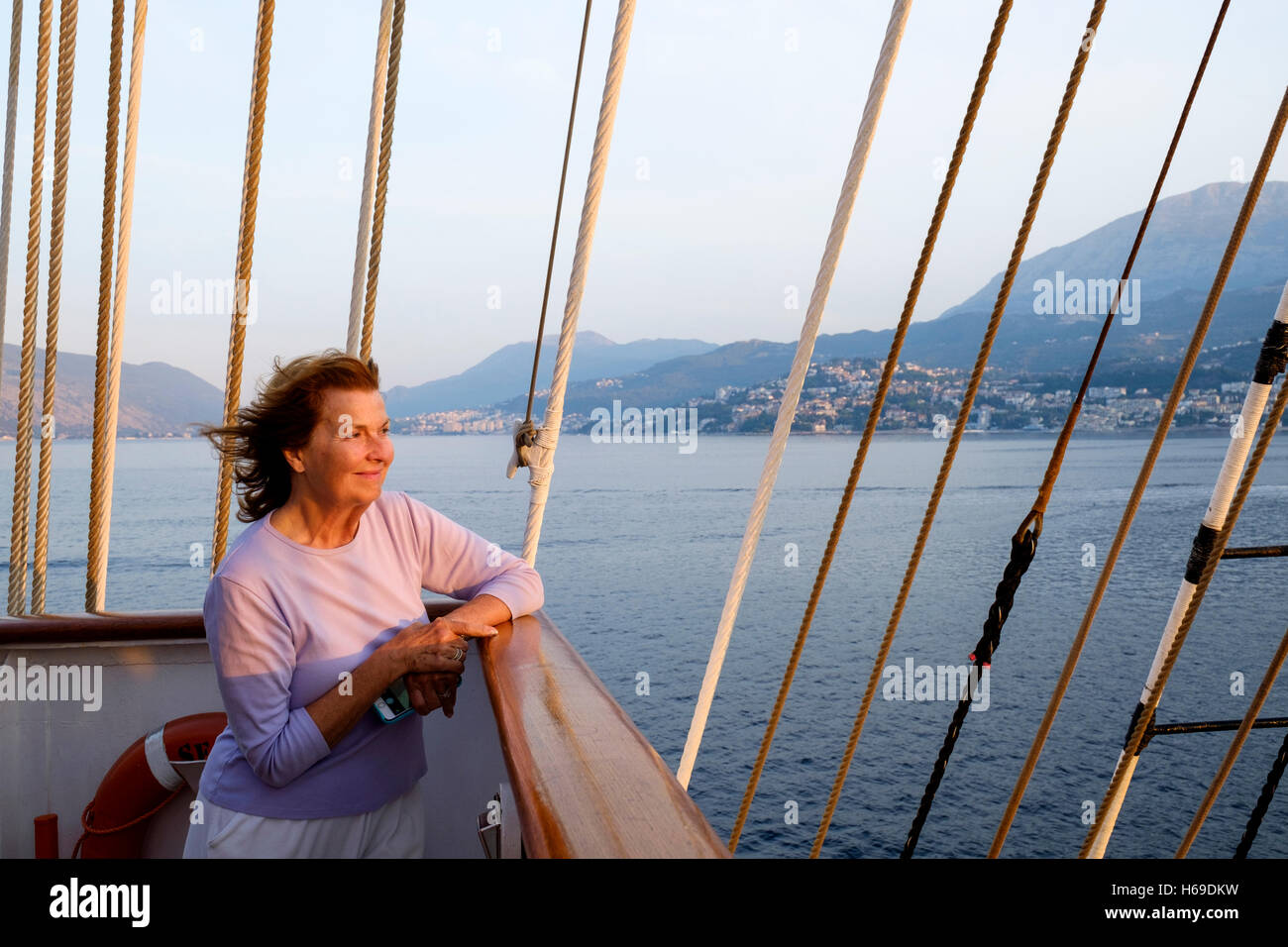 Lindblad Expeditions Gast sieht den Sonnenaufgang von der S.Y Sea Cloud an der Adria in der Nähe von Kotorfjord in Montenegro. Stockfoto