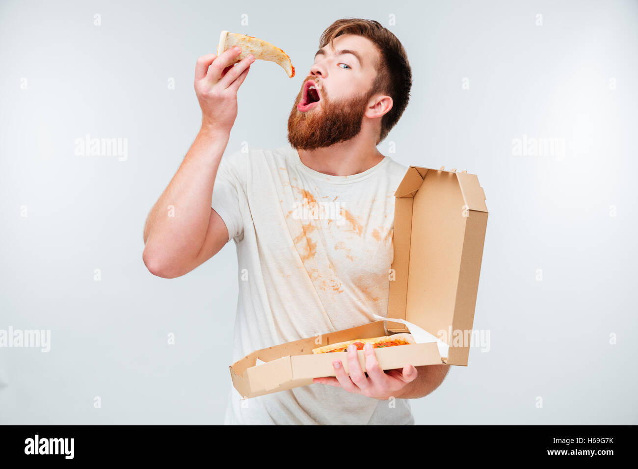 Lustig bärtigen hungrigen Menschen essen Pizza isoliert auf weißem Hintergrund Stockfoto