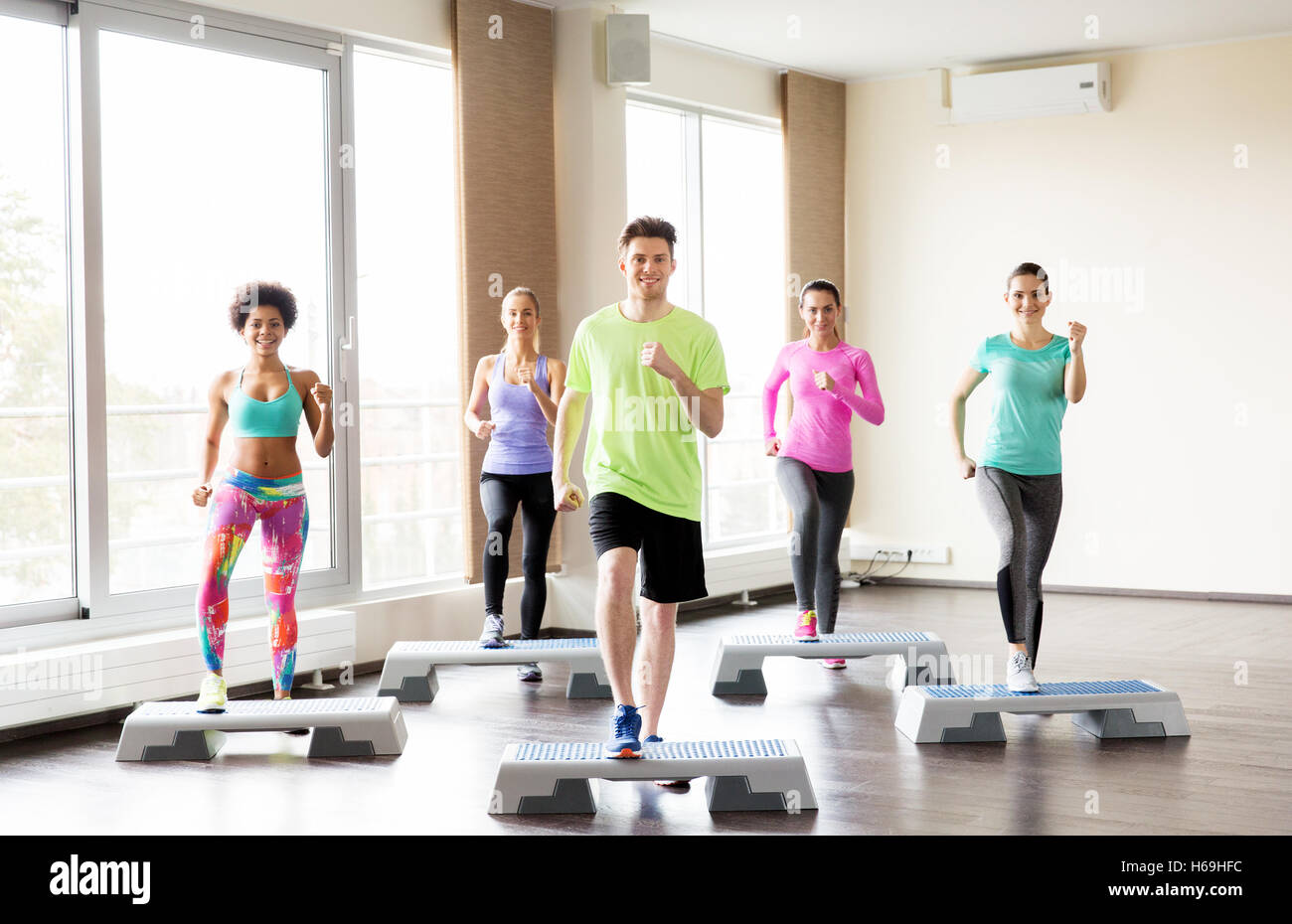 Gruppe von Menschen, die auf Stepper im Fitness-Studio trainieren Stockfoto