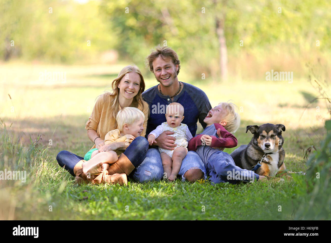 Eine glückliche Familie von fünf Personen, darunter Mutter, Vater, neues Baby junge und sein Bruder sind draußen in der sonnigen Garten wi Stockfoto
