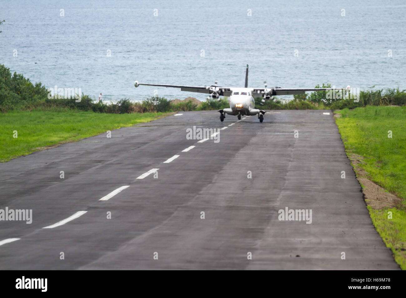 kleine lokale Flug Landung auf eine kleine asphaltierte Start-und Landebahn mit dem Pazifischen Ozean im Hintergrund in Costa Rica Stockfoto