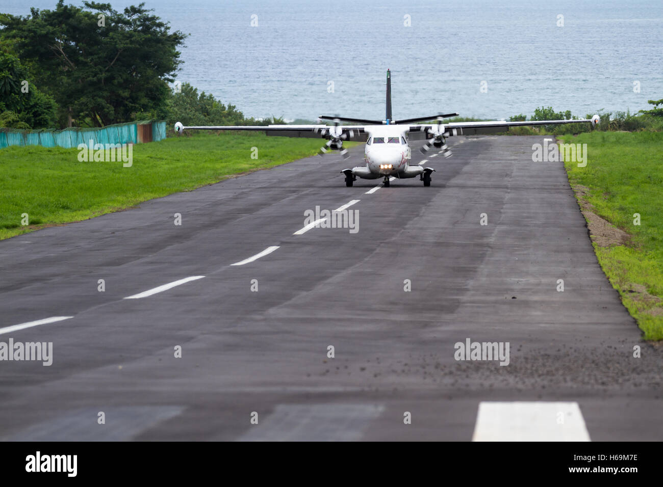 kleine lokale Flug Landung auf eine kleine asphaltierte Start-und Landebahn mit dem Pazifischen Ozean im Hintergrund in Costa Rica Stockfoto