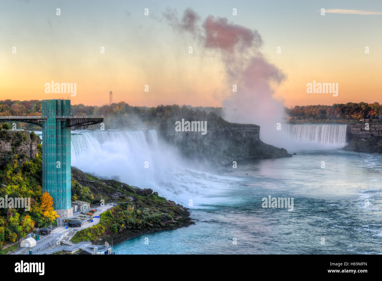 Licht der aufgehenden Sonne spiegelt sich in der Gischt der Horseshoe Falls mit den American Falls auf der linken Seite in Niagara Falls. Stockfoto