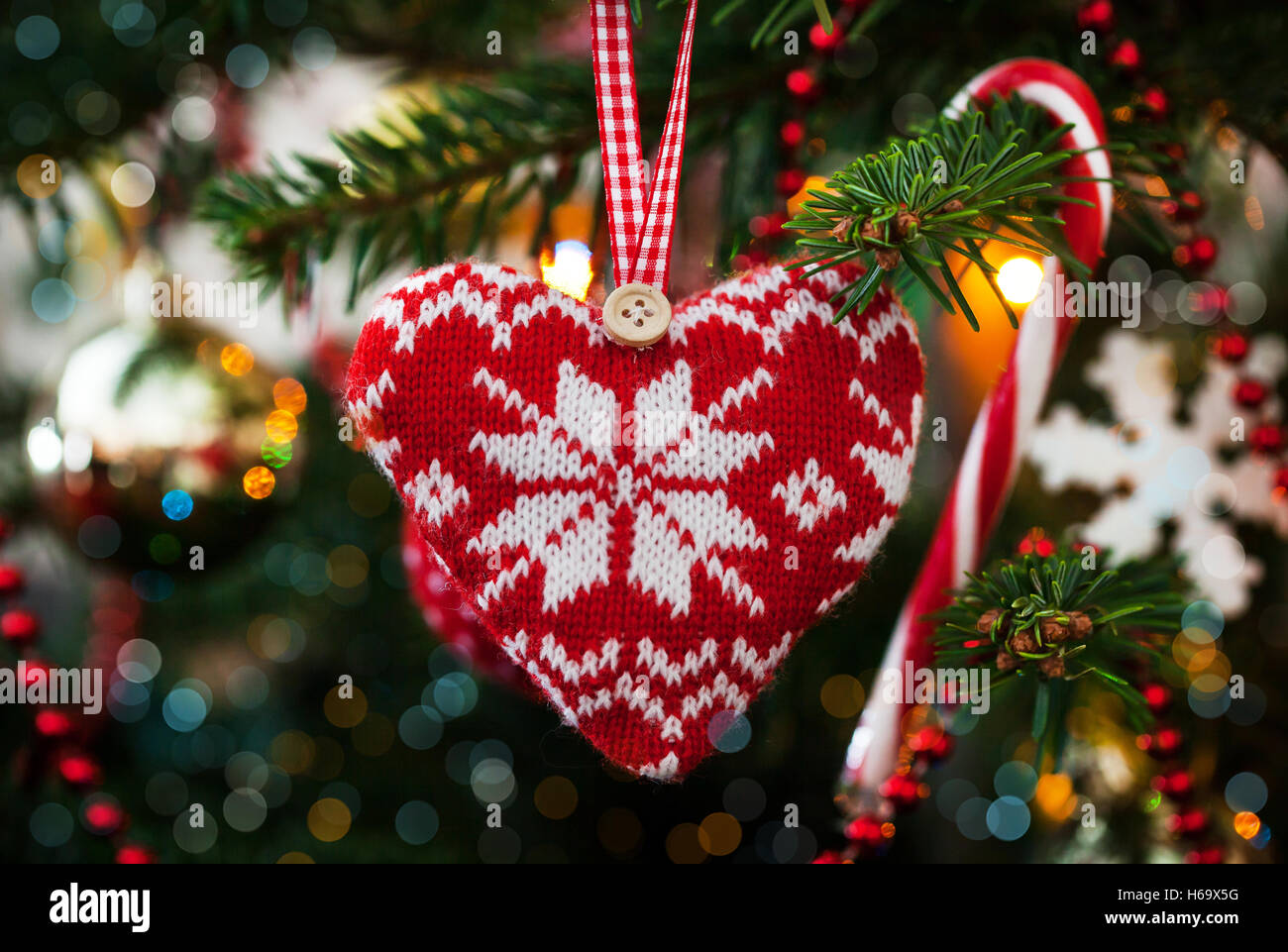 Weihnachten Deko Herz auf Xmas Tree und Garland Hintergrund gestrickt Stockfoto
