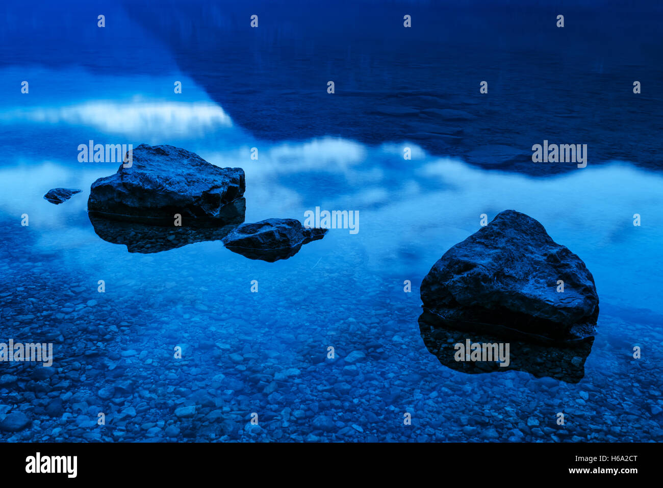 Felsen in seichten Seewasser in den Abend, ruhige idyllische Szene von Schönheit in der Natur Stockfoto