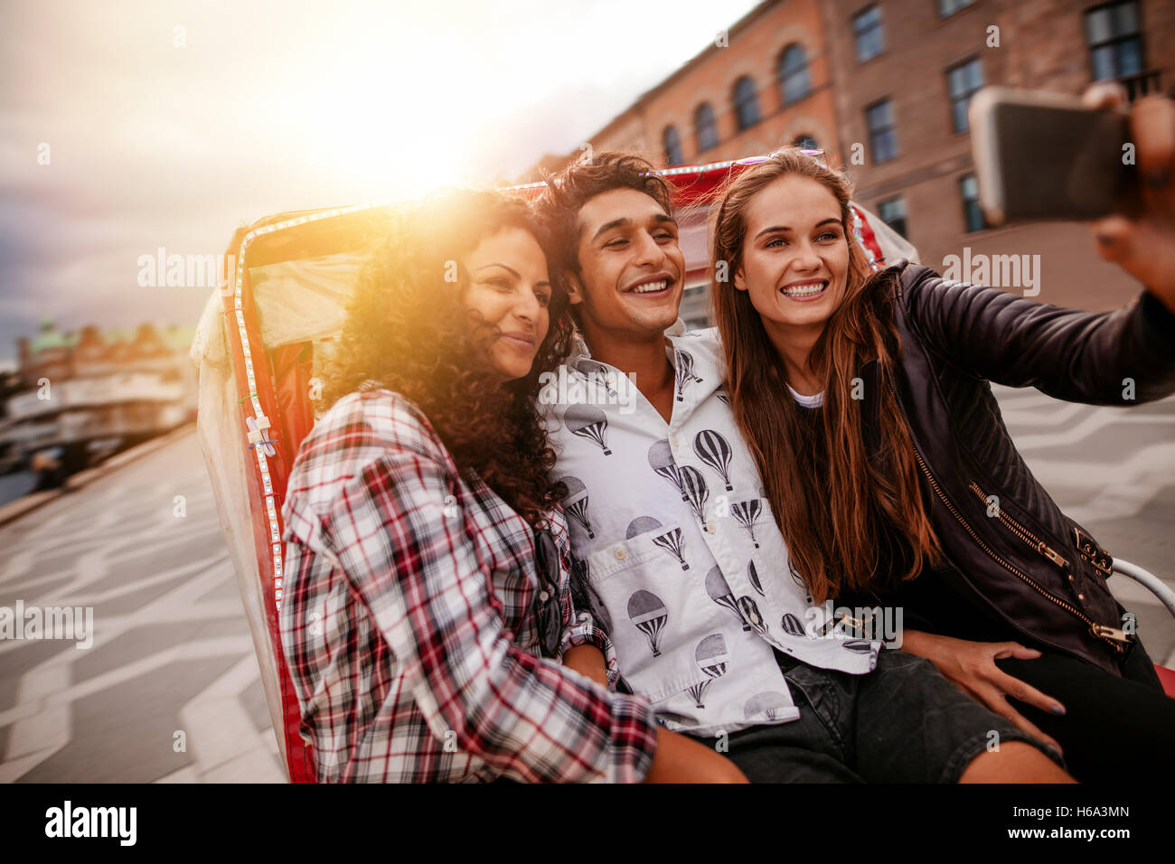 Teenager Freunde Spaß im Urlaub, Dreirad und nehmen Selfie mit Handy unterwegs. Junger Mann und Frauen reiten auf Stockfoto