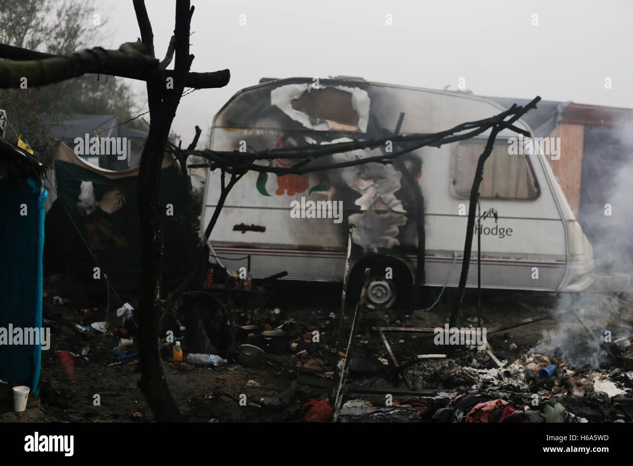 Calais, Frankreich. 26. Oktober 2016. Die benachbarten Karawane wurde durch das Feuer beschädigt. Die Zerstörung des Flüchtlingslagers Dschungel in Calais geht weiter am dritten Tag der Räumung, von Handwerkern, sowie durch Abbrennen der Hütten von den Flüchtlingen. Bildnachweis: Michael Debets/Pacific Press/Alamy Live-Nachrichten Stockfoto