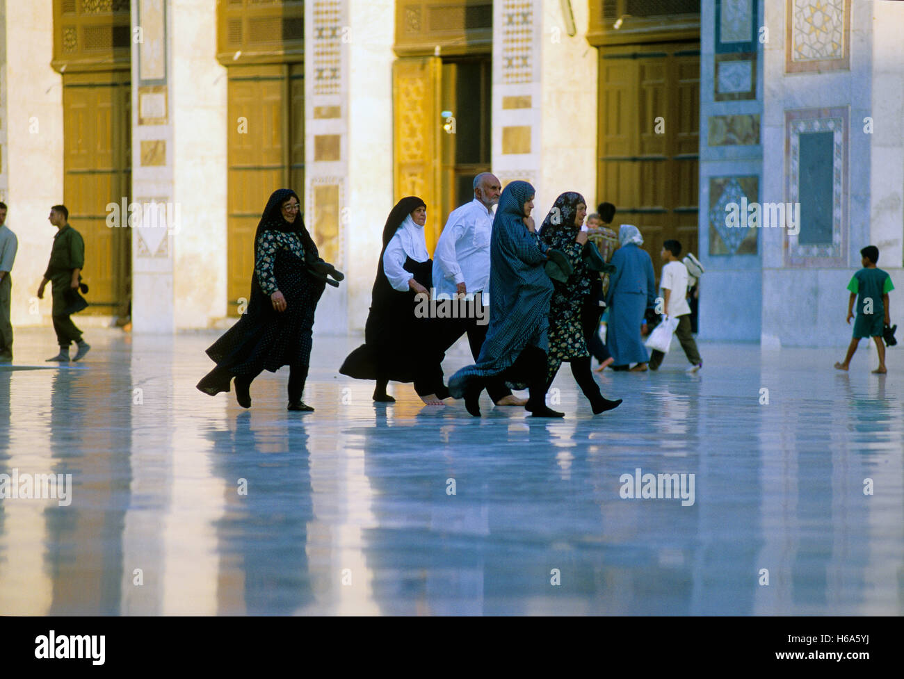 Eine Gruppe von iranischen Besucher im schillernden Hof des Umayyaden-Moschee in Damaskus. Am 21.08.2001 erfasst. Die Umayyaden-Moschee in Damaskus ist eine der ältesten der Welt. Es wurde im Stil einer alten Basilika erbaut und in vorislamischer Zeit war die Kathedrale, wo Johannes der Täufer gewidmet war. Traditionelle Aufzeichnungen, zufolge wird seinen Kopf in einem Schrein beibehalten. Die Moschee enthält einen umfangreiche Hof mit drei kleineren Nebengebäuden; Das Uhr-Haus, das Brunnen-Haus und dem berühmten Säulen Treasury, wo der Legende nach Stand Schätze früher gespeichert wurden. Foto: Matth Stockfoto