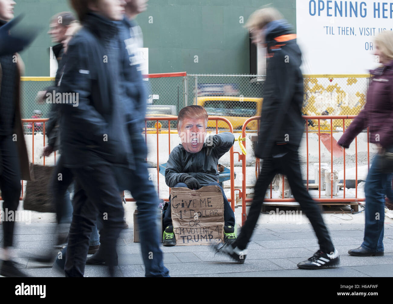 25. Oktober 2016 - New York, New York, USA - Mann trägt eine Maske mit Donald Trump Gesicht und hält eine Banner mit dem Text "Gib mir einen Dollar oder ich stimme für Trump" auf einer Straße in New York City. (Kredit-Bild: © Anna Sergeeva über ZUMA Draht) Stockfoto