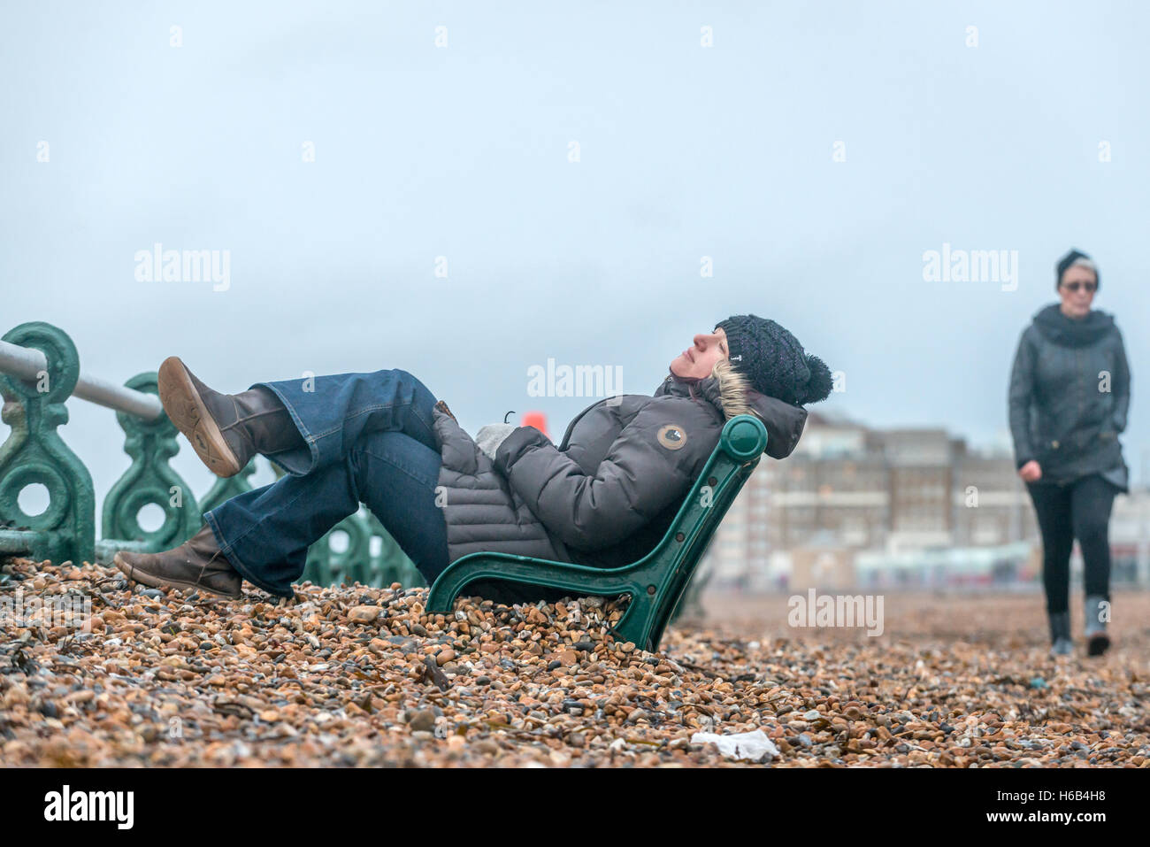 Anschluss an ein gewaltiger Sturm links Kiesel Strand angespült onshore, über Promenade Bänke. Stockfoto