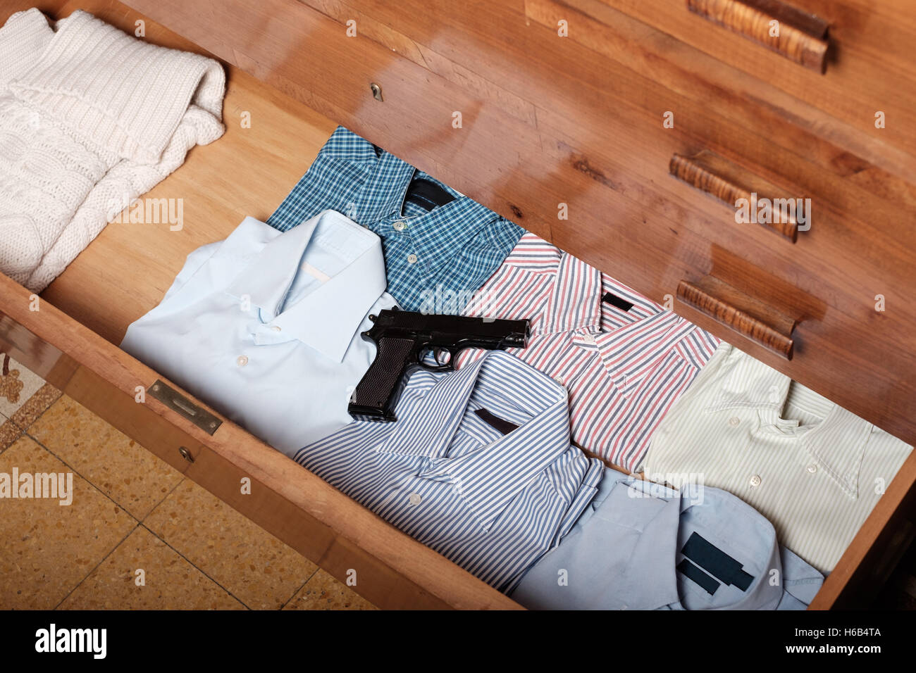 Waffe in eine Schublade voller Hemd zu Hause versteckt Stockfoto