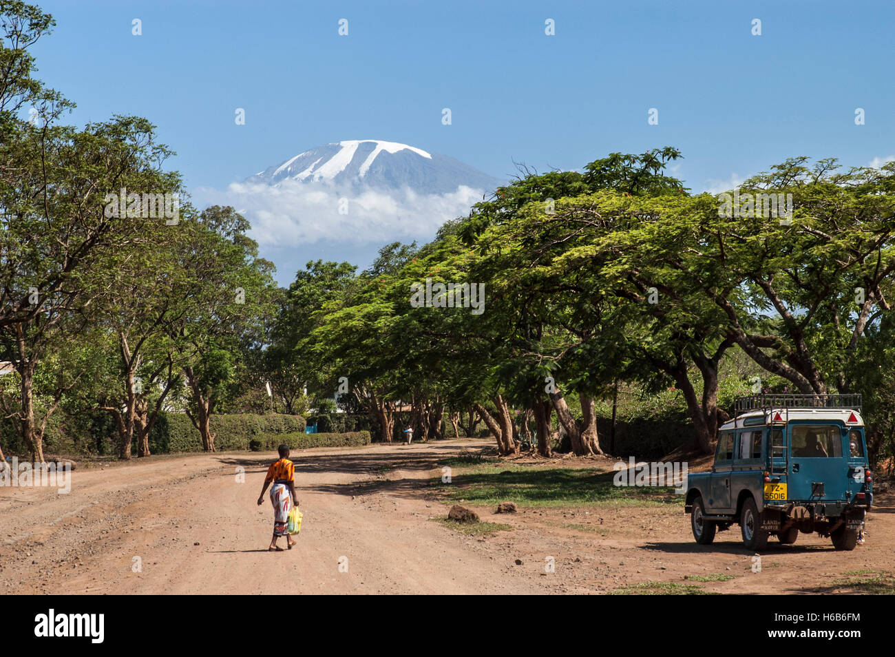 Kilimanjaro, Schotterstraße mit Fußgänger und Landrover, Moshi, Kilimanjaro Region, Tansania Stockfoto