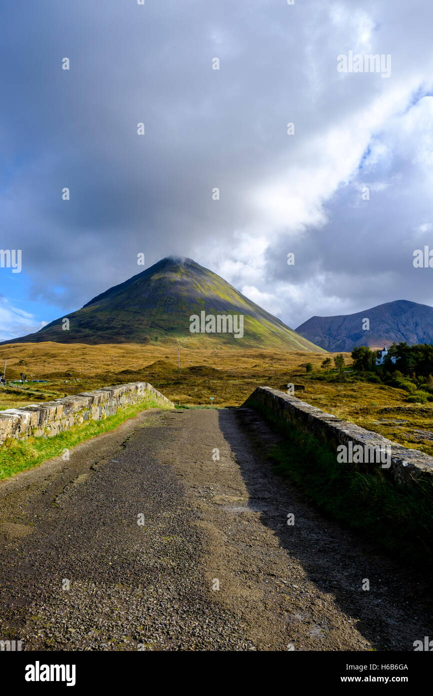 Blick von Sligachan über dem Bogen eine alte Steinbrücke, die Sonne scheint auf die konische Form des Glamaig, die Red Hills Stockfoto