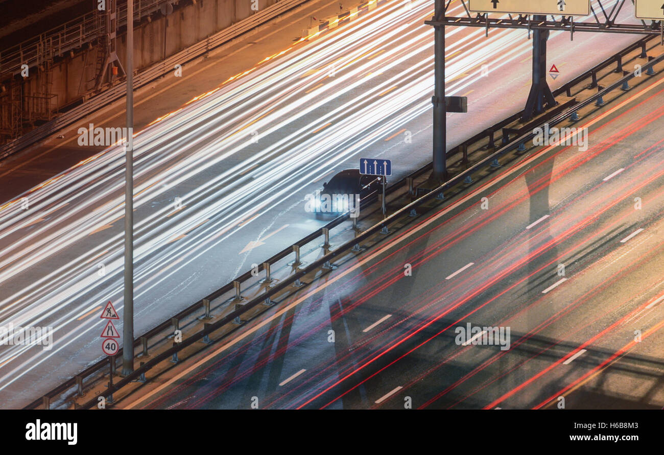 Kaputtes Auto zum Stillstand auf der Autobahn, die Aussicht von der Spitze. Die Lichtspuren des Autos auf einer Autobahn in der Nacht. Stockfoto
