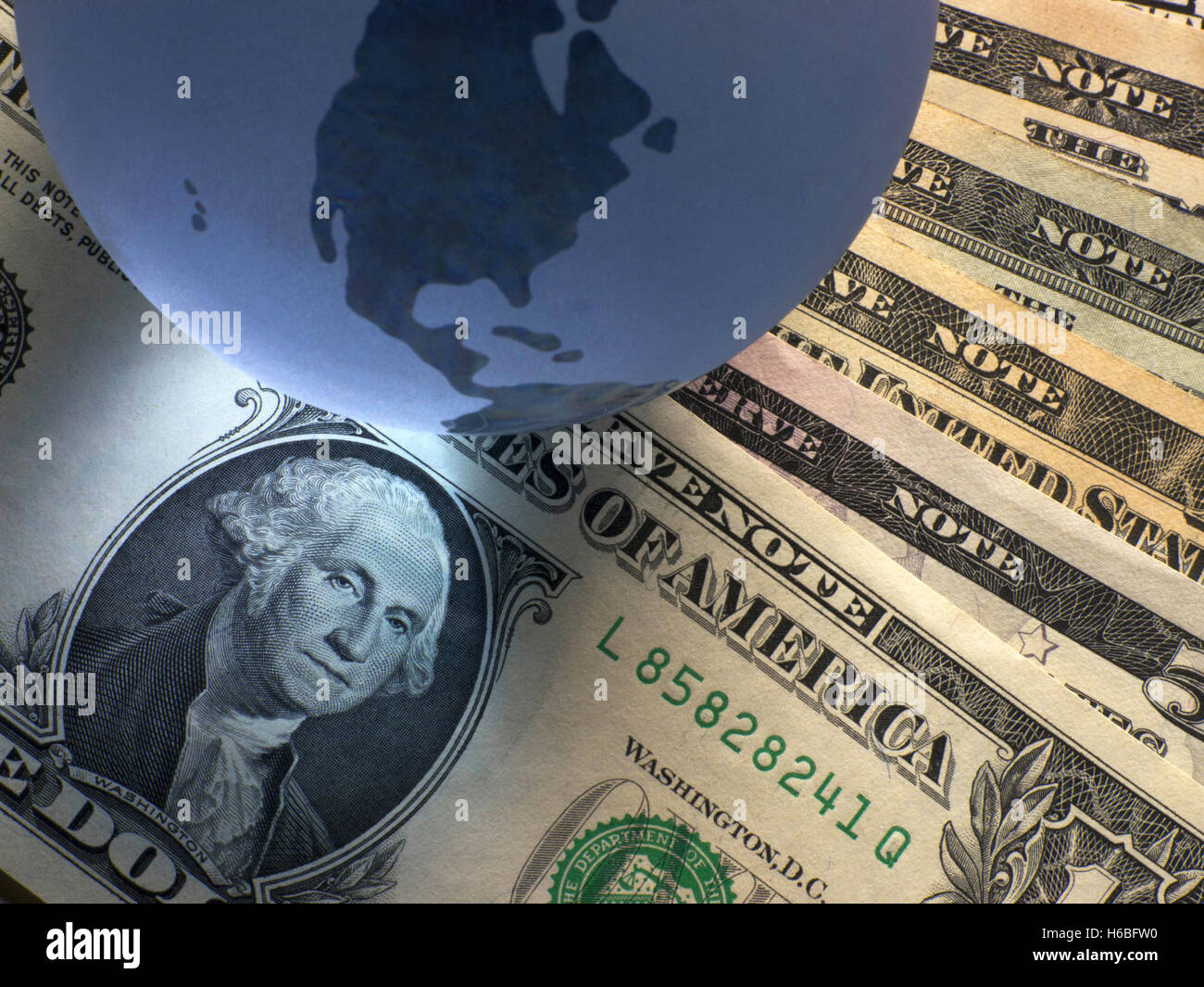 Globus mit Dollarnoten Stockfoto