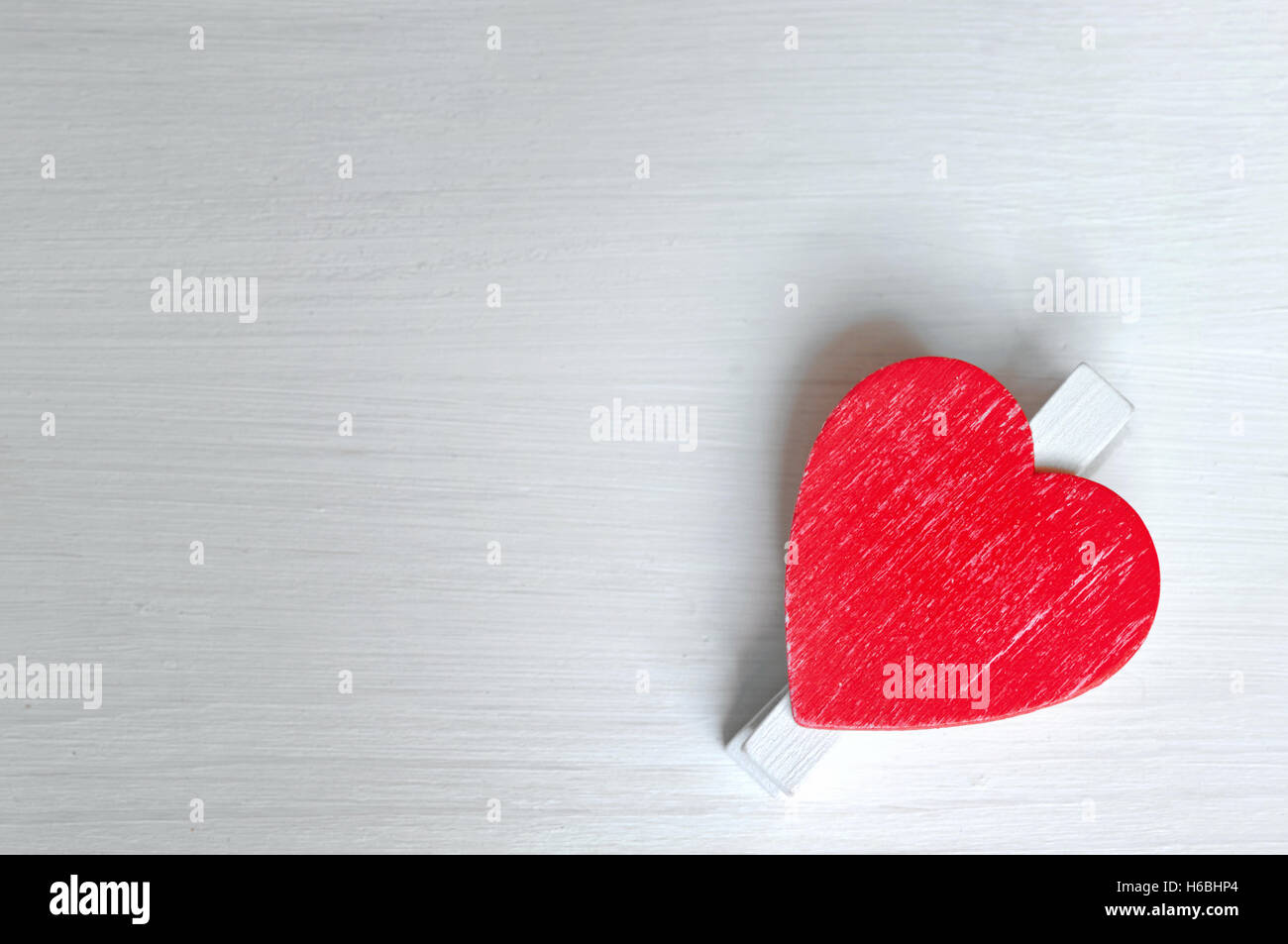 rotes Herz aus Holz isoliert auf weißem Holzbrett Stockfoto