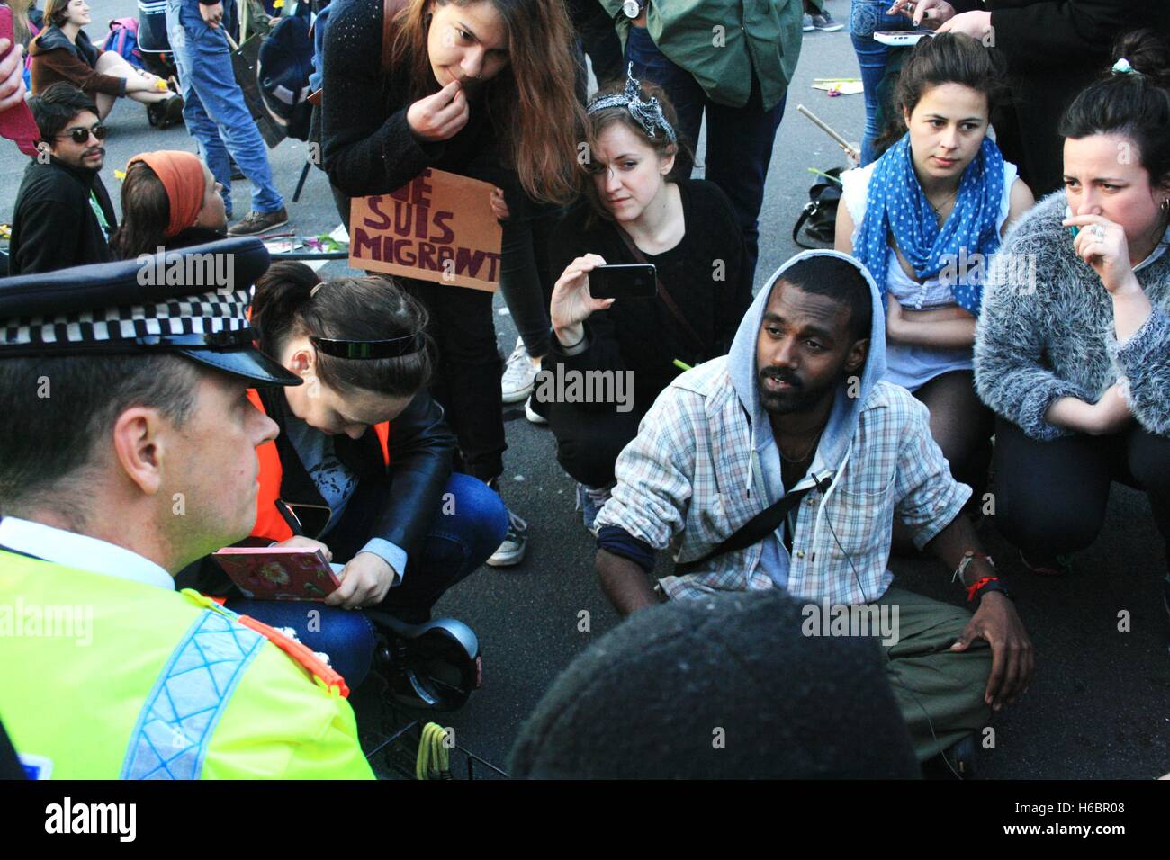 Ein Polizist spricht, einer der Organisatoren des London Black Umdrehungen während einer "sterben In" außerhalb des Parlaments in Solidarität mit denen, die versuchen, das Mittelmeer zu überqueren Leben verloren haben, bat ihn, Menschen von der Straße auf den Bürgersteig zu bewegen. Er weigert sich. Stockfoto
