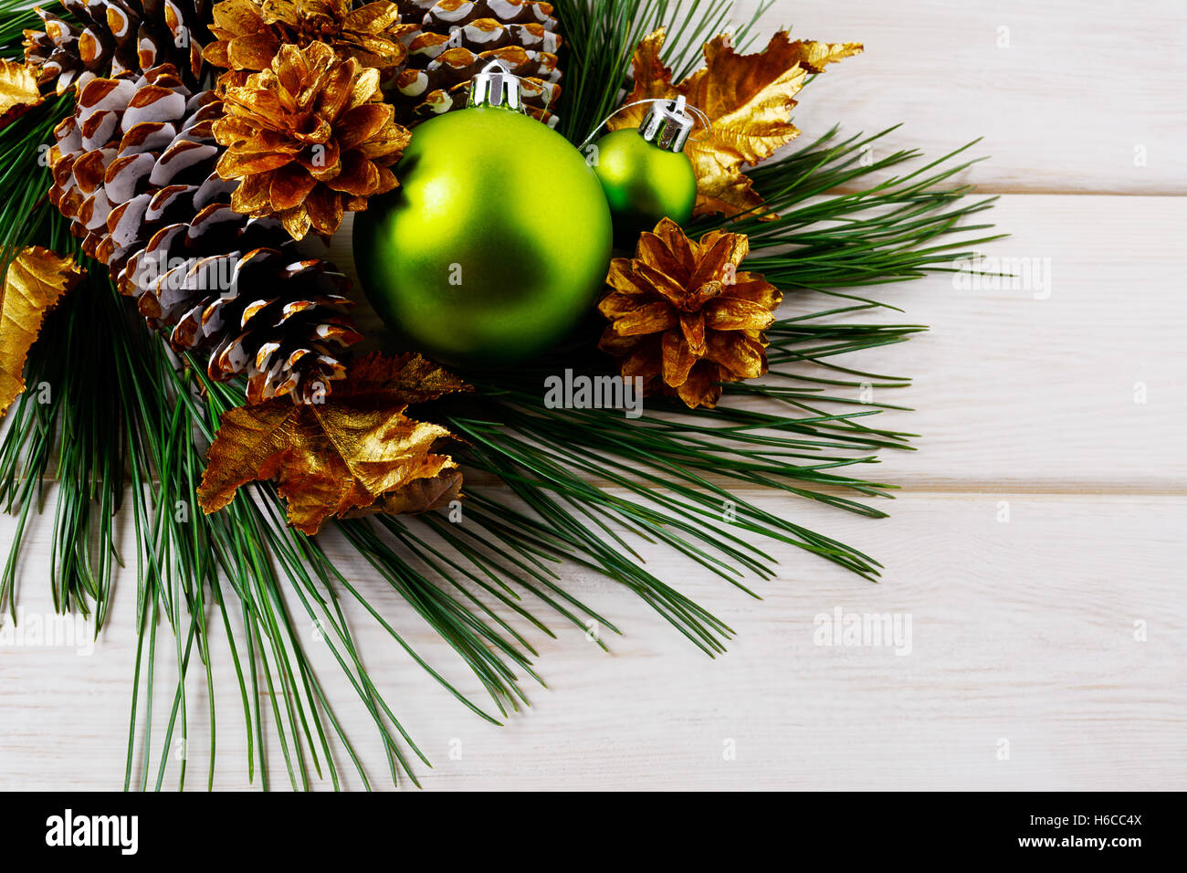 Weihnachten Hintergrund mit grünen Ornamenten und goldenen Tannenzapfen. Weihnachts-Party-Dekoration. Stockfoto
