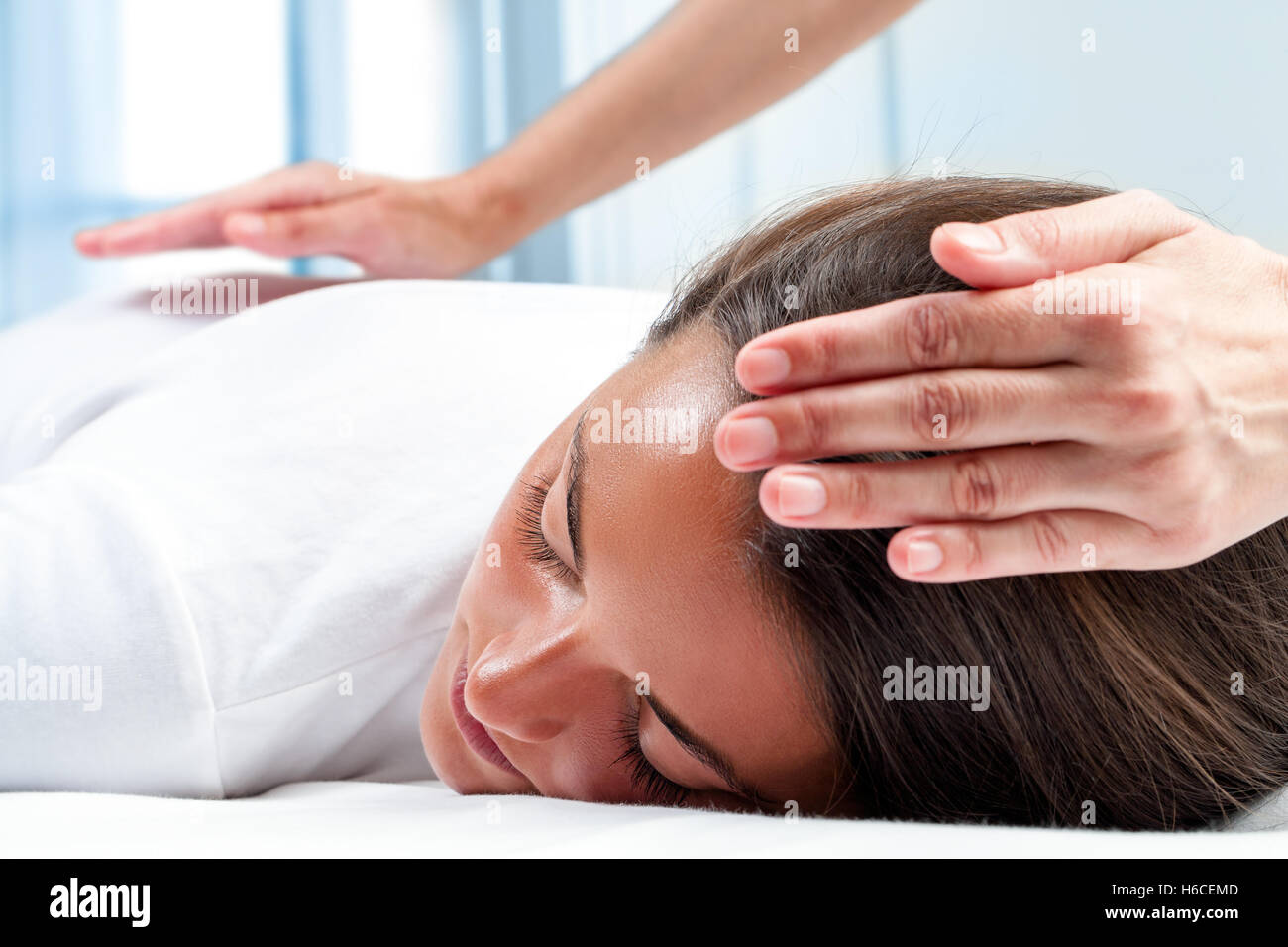 Therapeuten Hände Reiki Therapie auf Mädchen zu tun. Einer Hand am Kopf und eine hand auf Rücken. Stockfoto